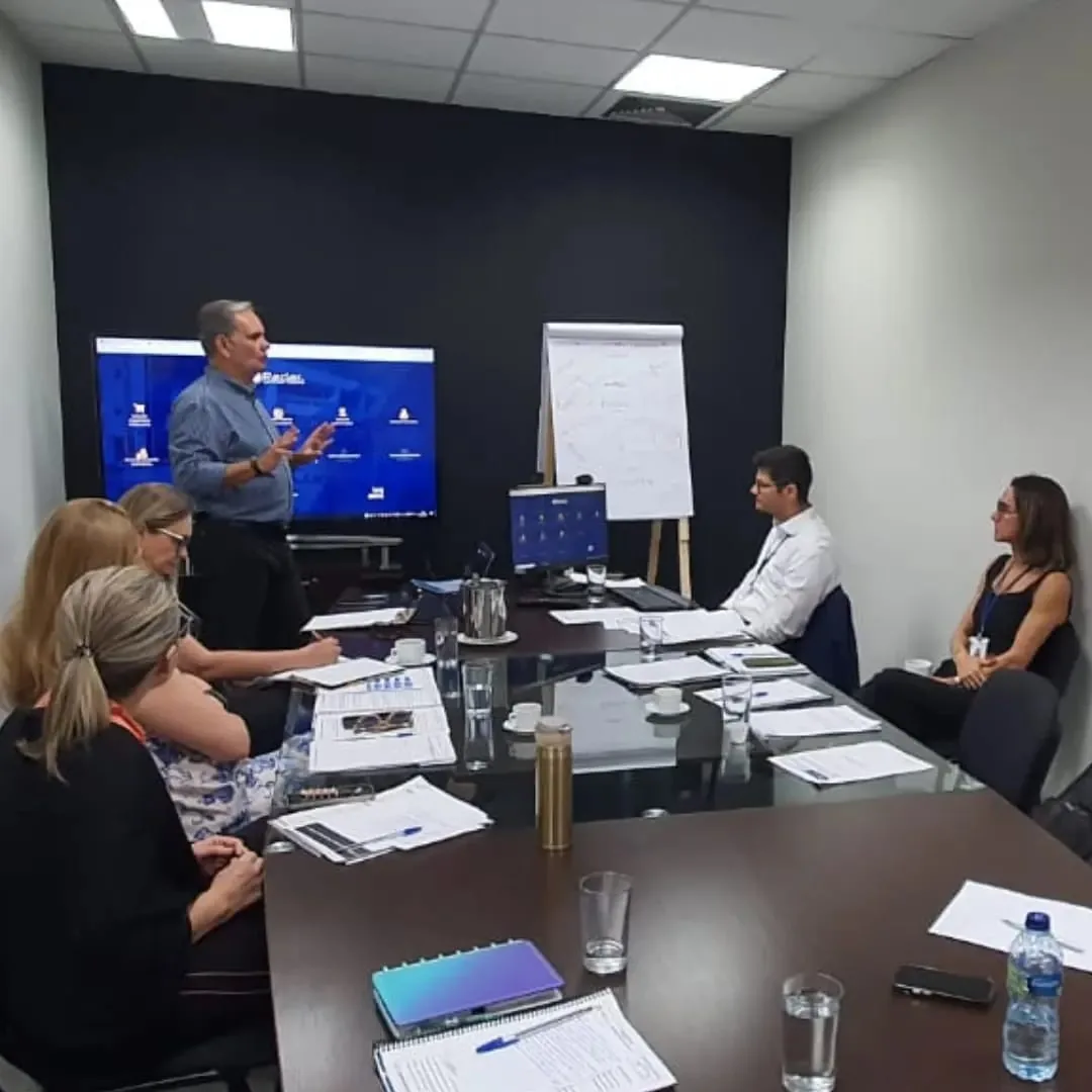 Nelson conduzindo uma discussão com profissionais à mesa.